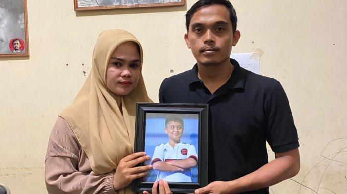 Kasus Kematian Afif Maulana, LBH Padang Hadirkan 3 Saksi yang Mandikan Jenazah ke Polresta 1 PERLIHATKAN FOTO— Afrinaldi (36) dan Anggun (32) berfoto dengan potret almarhum putra sulung mereka, Afif Maulana (13) di kantor LBH Padang.