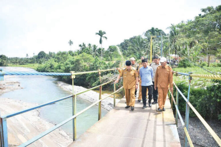 TINJAU— Bupati Agam Andri Warman, saat meninjau kondisi jembatan Simaruok.
