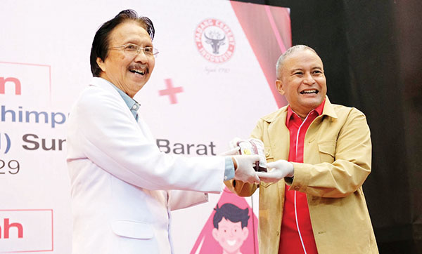 SERAHKAN KANTONG DARAH— Direktur Keuangan & Umum PT Semen Padang Oktoweri, menyerahkan kantong darah kepada PMI Kota Padang, dalam aksi sosial donor darah di GSG PT Semen Padang, Rabu (10/7).