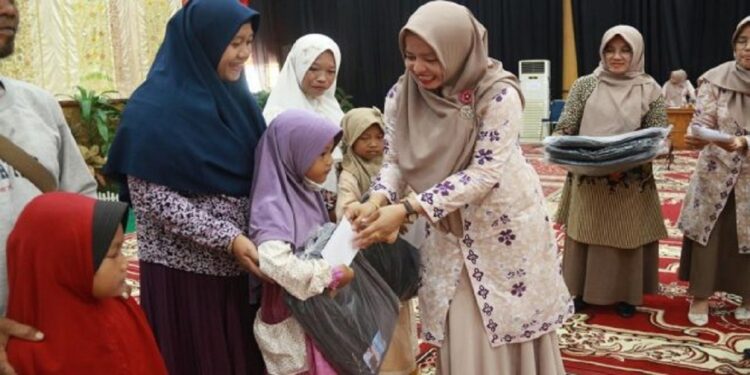 GOW Kota Solok Peduli Pendidikan, Bantu Perlengkapan Sekolah 1 SERAHKAN SERAGAM SEKOLAH—Ketua GOW Kota Solok, Dona Ramadhani Kirana menyerahkan paket pendidikan didampingi Kepala DPMPPA Kota Solok Delfianto.