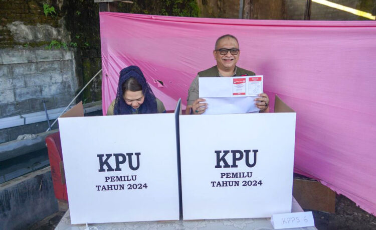 GUNAKAN HAK SUARA— Pj Wako Padang Andree Algamar bersama istri, Andree Algamar, menyalurkan hak pilih pada PSU anggota DPD RI, Sabtu (13/7) pagi, di TPS 01 Kelurahan Rimbo Kaluang, Kecamatan Padang Barat.