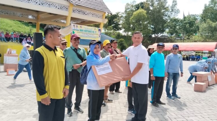 Semarak Puncak Peringatan Hari Koperasi ke-77, Ratusan Anggota Koperasi Ikuti Gerak Jalan Santai 1 BERIKAN HADIAH— Sekda Limapuluh Kota Herman Azmar saat memberikan hadiah hiburan kim pada puncak peringatan hari Koperasi di Limapuluh Kota.