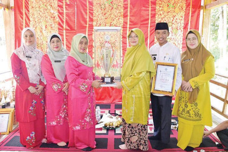 SERAHKAN PIALA— Ketua TP PKK Kabupaten Agam, Ny. Yenni Andri Warman, menyerahkan Piala Lomba Gerakan PKK Tingkat Provinsi Sumatera Barat, kepada Ketua PKK Nagari Sitalang di Balairung Wisata Sarasah Nagari Sitalang, Kecamatan Ampek Nagari, Jumat (26/7).