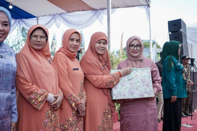 SERAHKAN HADIAH— Ketua TP PKK Sumbar Harneli Mahyeldi serahkan hadiah pada  Ketua TP-PKK Solok Selatan, Ny. Hj. Erniati Khairunas, saat puncak acara Jambore Kader PKK Berprestasi Tingkat Sumbar di Alahan Panjang, Kabupaten Solok.