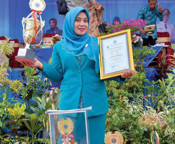 TP-PKK Agam Juara Umum HKG PKK ke-52 Tingkat Provinsi Sumbar 1 JUARA UMUM— Ketua TP-PKK Kabupaten Agam, Ny. Yenni Andri Warman bersama sejumlah trofi dan penghargaan yang diraih oleh TP-PKK Agam hingga menjadi juara umum pada HKG PKK ke-52 tingkat Provinsi Sumbar.