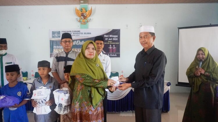 BANTUAN— Wakil Bupati Pasaman Barat, Risnawanto, serahkan bantuan pada anak-anak yang ikut sunatan massal.