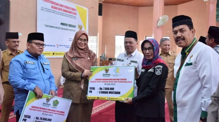 SERAHKAN—Sekretaris Daerah Kota Sawahlunto Ambun Kadri menyerahkan simbolis peluncuran program Kampung Zakat dan Bapak Asuh Anak Stunting yang merupakan program inovasi BAZNas Sawahlunto.