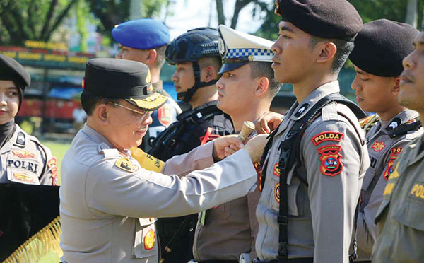 APEL— Kapolda Sumbar Irjen Pol Suharyono memasang tanda pelaksanaan Operasi Mantap Praja Singgalang kepada personel dalam apel gelar pasukan.