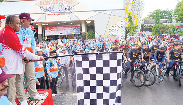 PELEPASAN PESERTA—  Pj Wali Kota Padang, Andree Algamar beserta istri, Ny Vanny Algamar, melepas ribuan pesepeda serta menyerahkan hadiah kepada Apri Siswandi (68), peserta dari Pengambarin, Kecamatan Lubuk Begalung, yang berhasil memenangkan doorprize utama sepeda motor dalam Padang Gowes Adventure, Minggu (4/8).