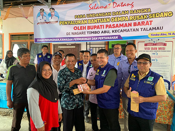 SERAHKAN—Sekretaris Daerah (Sekda) Hendra Putra menyerahkan secara simbolis bantuan untuk rumah rusak sedang yang terdampak gempa bumi kepada 72 Kepala Keluarga (KK) di Nagari Simpang Timbo Abu Kajai, Kecamatan Talamau.