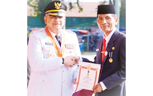 ANUGERAH TANDA KEHORMATAN— Pj Wako Andreee Algamar menyerahkan anugerah tanda kehormatan Satyalancana Karya Satya  dari Presiden Republik Indonesia, Joko Widodo kepada ASN Pemko Padang, usai upacara bendera peringatan HUT ke-79 RI, di Lapangan Imam Bonjol.