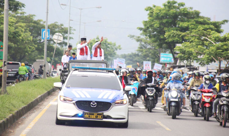 DIARAK KELILING KOTA— Pasangan calon Wali Kota dan Wakil Wali Kota Padang yang diiusung dari Partai Gerindra dan PAN, Hendri Septa-Hidayat diarak keliling kota menuju Kantor KPU Kota Padang. Arak-arakan ini dipadati ratusan massa pendukung dari berbagai elemen masyarakat, Kamis (29/8).