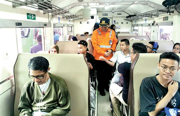 SAPA PENUMPANG KA—  Vice President KAI Divre II Sumbar, Sofan Hidayah menyapa penumpang yang menaiki KA Pariaman Ekspres, Sabtu (10/8).