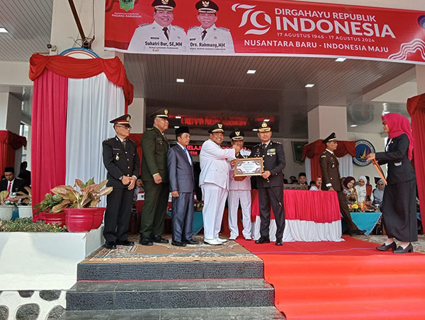 TERIMA—Kapolres  Padangpariaman AKBP  Ahmad Faisol  Amir saat terima [enghargaan dari bupati