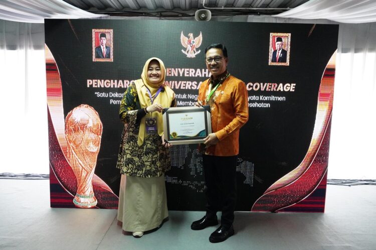 PENGHARGAAN—Bupati Solok Selatan H. Khairunas  bersama penghargaan Universal Health Coverage (UHC).