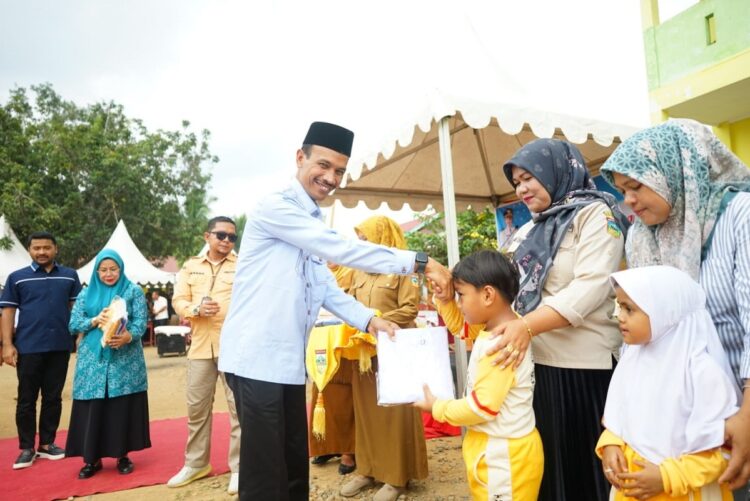 bagikan — Wakil Bupati Solok Selatan H. Yulian Efi saat membagikan seragam graris di sebuah TK Kecamatan Sangir Batang Hari