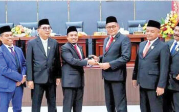 Ketua DPRD Sementara Muharlion menerima Palu pimpinan dari Ketua DPRD Sebelumnya Syafrial Kani