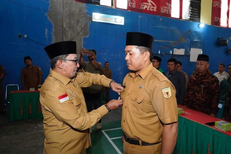 SEMATKAN—Bupati Eka Putra sematkan pin Wali Nagari Sungayang pada Yoghi Alfinder.