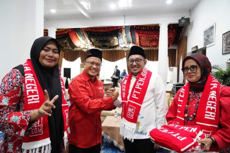 PELEPASAN JAMAAH UMRAH— Bupati Eka Putra bersalaman dengan pimpinan AET Batusangkar Ustadz Aulia Rijal, saat pelepasan 100 Jamaah Umrah menuju Tanah Suci, di Indo Jalito.