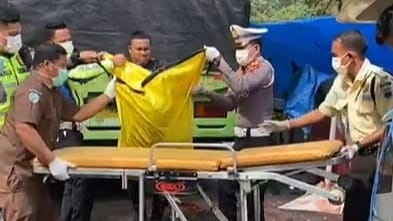 TERGILAS TRUK— Jenazah pemotor yang tewas akibat tergilas truk dievakuasi oleh personel Satlantas Polres Padangpanjang.