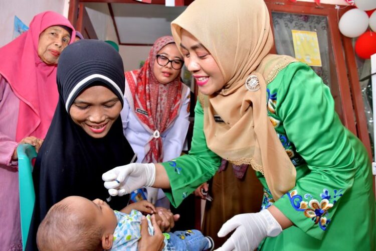 IMUNISASI POLIO— Ketua TP-PKK Kabupaten Agam, Ny Yenni Andri Warman berikan imunisasi polio di Posyandu Nagari Parit Panjang, Kecamatan Lubuk Basung, Selasa,(13/8).