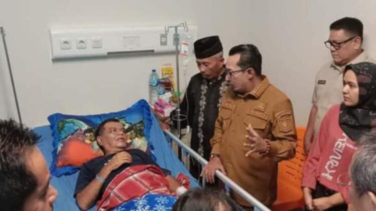 BEZUK WARGA— Bupati Tanah Datar Eka Putra saat menjenguk seorang warga yang sedang dirawat di RSUD Ali Hanafiah SM Batusangkar.