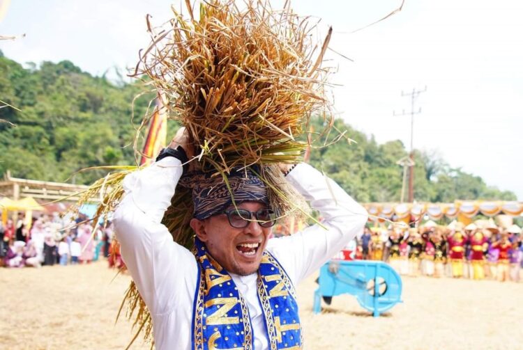 Nagari Tanjuang Gelar Iven Mairiak Jo Manongkang Padi 1 IVEN NAGARI—Bupati Tanah Datar Eka Putra mengangkut potongan padi untuk ditongkang dalam iven “Mairiak jo Manongkang Padi” yang digelar NAgari Tanjuang.