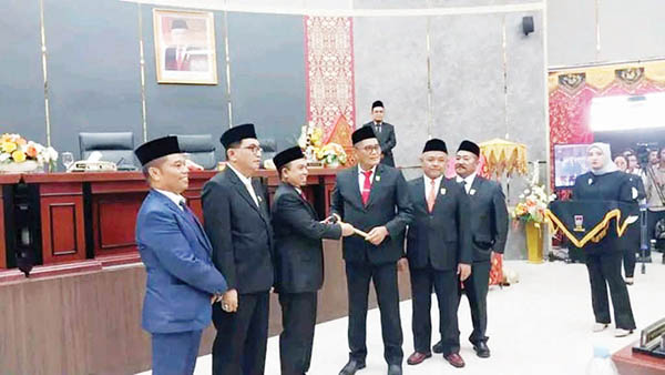 PIMPINAN SEMENTARA— Ketua DPRD periode 2019-2024, Syafrial Kani menyerahkan palu kedewanan kepada Pimpinan Sementara DPRD Kota Padang periode 2024-2029 Muharlion, saat pelantikan anggota DPRD, Rabu (14/8).