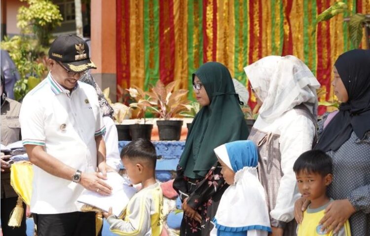 Giliran Kecamatan Pauh Duo Terima Seragam untuk Siswa Baru 1 SERAHKAN— Bupati Solok Selatan Khairunas serahkan baju seragam sekolah di Kecamatan Pauh Duo.