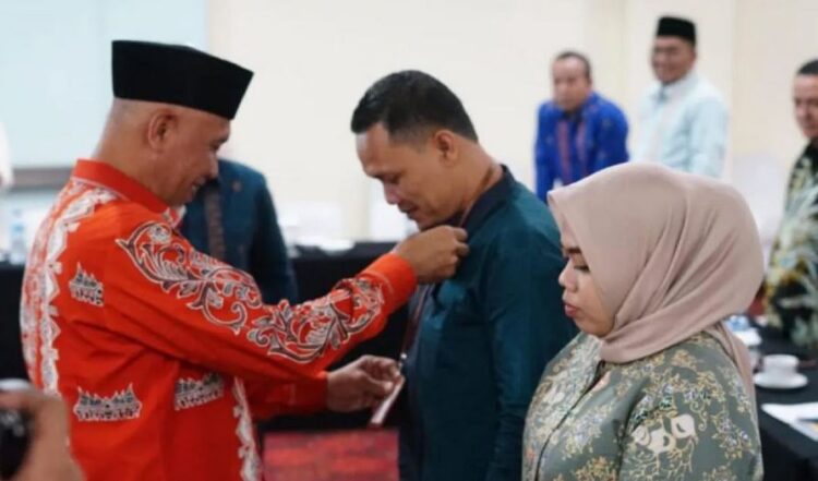 Pemko Sawahlunto Fasilitasi Orientasi Pendalaman Materi Anggota DPRD 1 KALUNGKAN—Gubenur Sumbar Mahyeldi Ansharullah mengalungkan tanda peserta orientasi dan pendalaman materi anggota DPRD Sawahlunto kepada pimpinan sementara DPRD Fatrionaldi, Selasa (20/8).