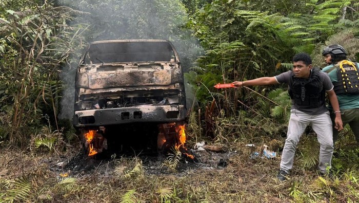 DIBUNUH— Polisi saat ke lokasi truk yang dibakar KKB dan sopirnya dibunuh secara brutal di Yahukimo, Papua Pegunungan.