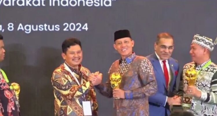 RAIH—Bupati Pasaman, Sabar AS saat meraih penghargaan UHC.