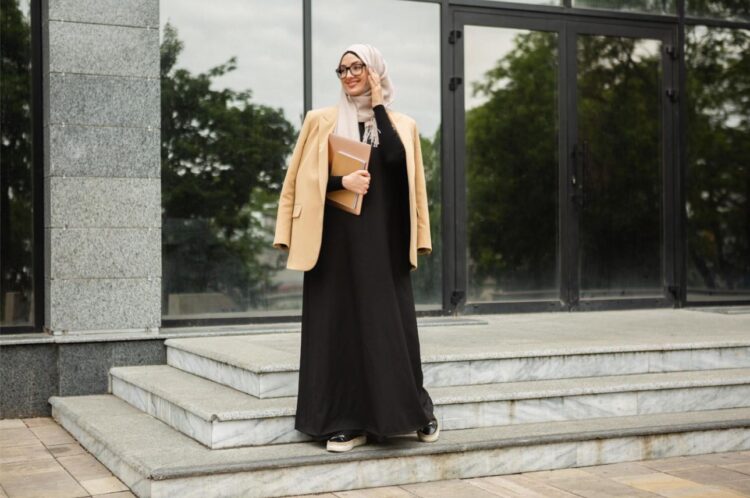 Rekomendasi Dress Muslim Kekinian untuk Wanita Muda 1 Sumber : https://www.freepik.com/free-photo/modern-stylish-muslim-woman-hijab-business-style-jacket-black-abaya-walking-city-street-with-laptop_15070045.htm#query=muslim%20dress&position=30&from_view=keyword&track=ais