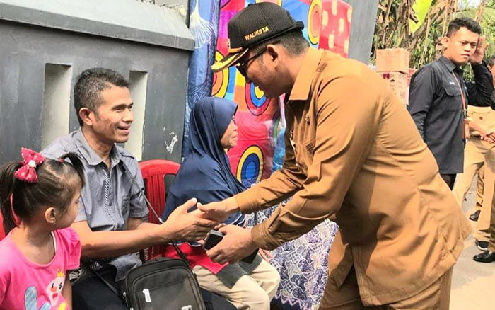 Hendri Septa Cetak Sejarah Semasa jadi Wali Kota,Sukses Turunkan Angka Kemiskinan 3 Tahun Berturut-turut 1 BERIKAN BANTUAN— Hendri Septa bersalaman dengan penyandang disabilitas setelah berikan bantuan usaha ekonomi produktif (pijat refleksi) sebagai bagian program turunkan angka kemiskinan saat jadi Wali Kota Padang.