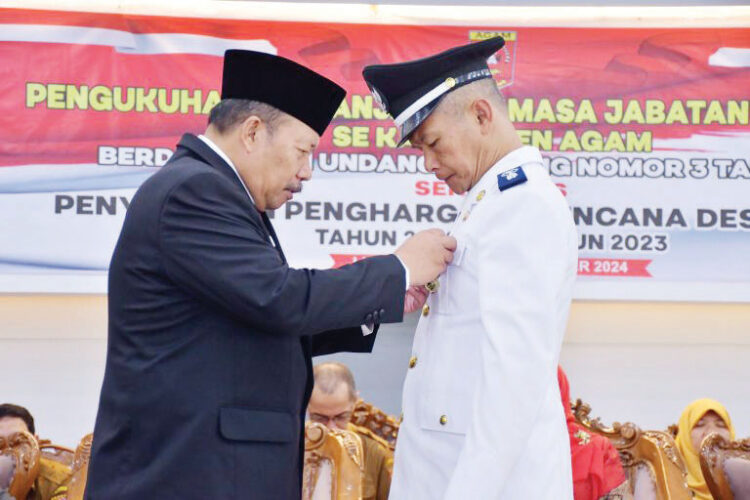 PASANGKAN LENCANA— Bupati Agam, Dr H Andri Warman memasangkan Lencana Desa Mandiri kepada nagari yang berstatus Mandiri, di Balairung Rumah Dinas Bupati Agam, Senin (9/9).