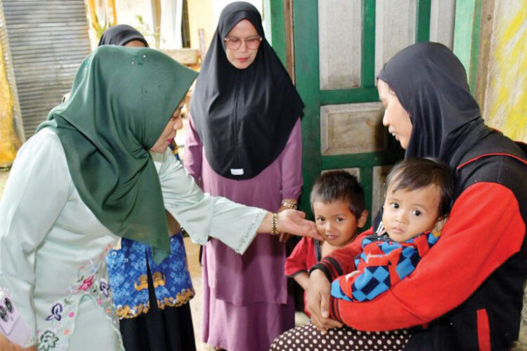 KEPEDULIAN— Ketua LKKS Kabupaten Agam Ny.Yenni Andri Warman, perlihatkan kepeduliannya terhadap warga dengan menyalurkan bantuan kepada dua orang anak yang menderita penyakit di Nagari Dalko, Kecamatan Tanjung Raya, Selasa (17/9).