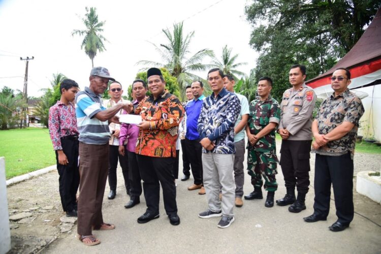 BERIKAN KARTU JKN— Bupati Padangpariaman Suhatri Bur memberikan kartu Jaminan Kesehatan Nasional (JKN) dan Kartu Indonesia Sehat (KIS) kepada 3.549 jiwa penerima manfaat.