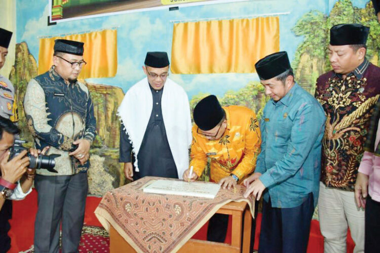 TANDATANGAN PRASASTI— Bupati Agam Andri Warman menandatangani prasati sekaligus meresmikan aula dan ruang belajar Ponpes Tahfiz Qur’an Baiturrahman, Kamis (5/9).