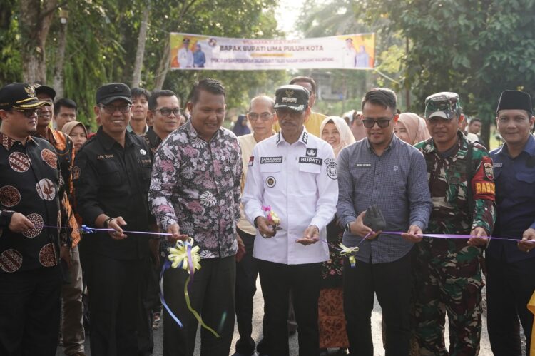 GUNTING PITA—Bupati Lima Puluh Kota, Safaruddin Dt.Bandaro Rajo, gunting pita  saat peresmian jalan Jorong Bukit Talao, Nagari Gunuang Malintang, Kecamatan Pangkalan.