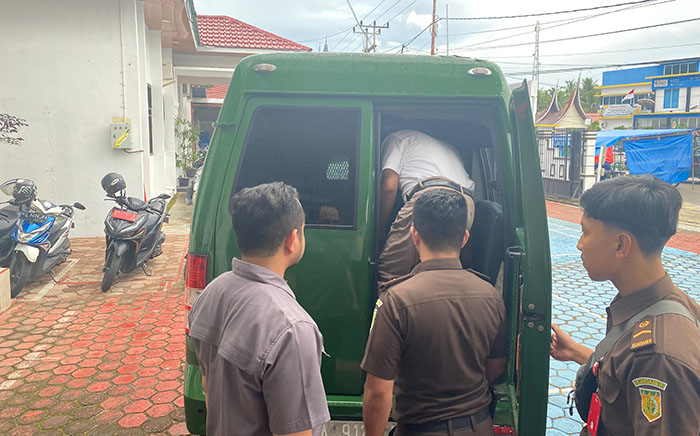 KORUPSI— Mantan Ketua DPRD Sijunjung periode 2019-2024 Bambang Surya Irwan yang ditetapkan sebagai tersangka korupsi digiring ke mobil tahanan Kejari Sijunjung untuk menjalani penahanan di Lapas.