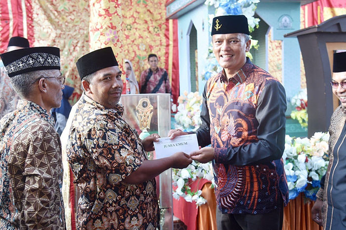 SERAHKAN—Pj Wako Pariaman Roberia   saat serahkan bonus pada romngan kafilah