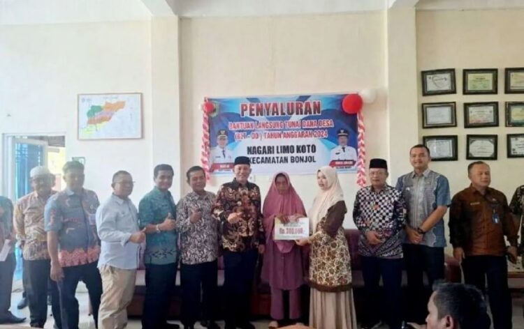 SERAHKAN BLT— Bupati Pasaman Sabar AS menyerahkan Bantuan Langsung Tunai (BLT) untuk warga di Nagari Limo Koto Kecamatan Bonjol.