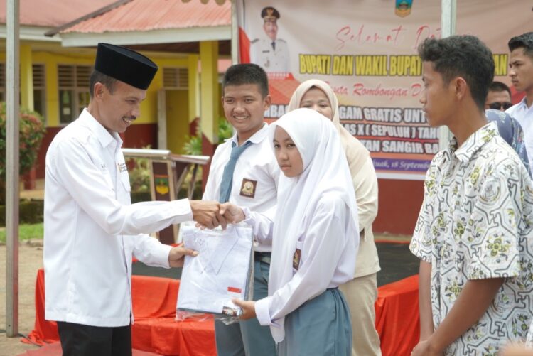 Tiga SMA dan SMK di Sangir Balai Janggo Terima Bantuan Seragam 1 SERAHKAN SERAGAM SEKOLAH— Wakil Bupati Solok Selatan Yulian Efi serahkan bantuan seragam pada perwakilan siswa.