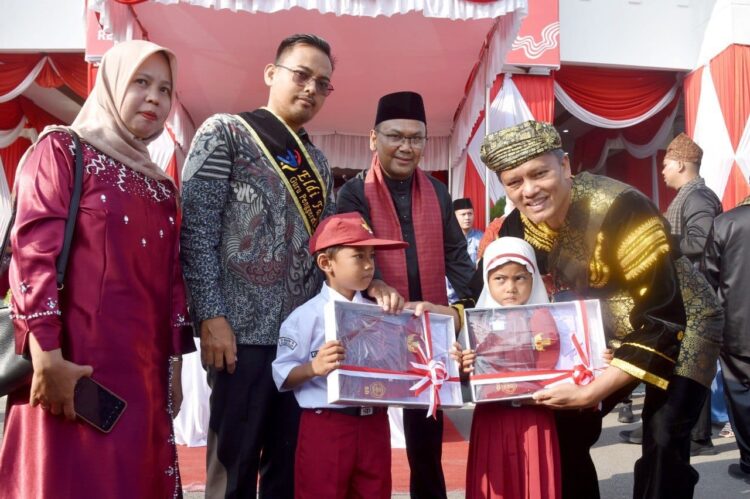 872 Siswa Kurang Mampu Terima Seragam Sekolah Gratis 1 SERAHKAN SERAGAM SEKOLAH— Pjs Wali Kota Pariaman Roberia serahkan baju seragam untuk murid murid SD kurang mampu, yang merupakan bantuan dari CSR Bank Nagari.