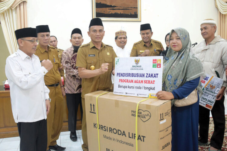 SIMBOLIS— 
Pjs Bupati Agam, Endrizal, meyerahkan secara simbolis ZIS tahap II untuk Agam Wailayah timur di Mess Pemkab Agam Belakang Balok, Bukittinggi, Selasa (29/10).