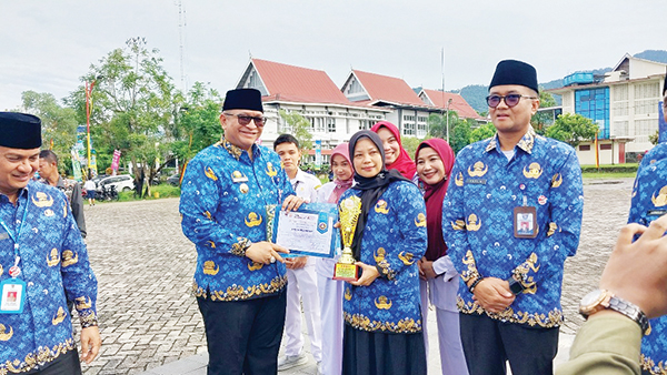 PEMENANG LOMBA— Pj Wako Padang Andree Algamar menyerahkan bonus kepada pemenang lomba paduan suara Hymne dan Mars Kota Padang antar OPD di lingkungan Pemko Padang  diraih oleh Dinkes, usai upacara peringatan HUT Korpri ke 53 di lapangan Balaikota Padang, Jumat (29/11).