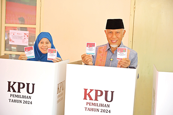 PEMUNGUTAN SUARA— Gubernur Sumbar Mahyeldi Ansharullah bersama Ketua TP PKK Sumbar Harneli Bahar, memberikan hak suaranya di TPS 005 Kompleks Kampus STISIP Imam Bonjol Jati Baru, Kota Padang.