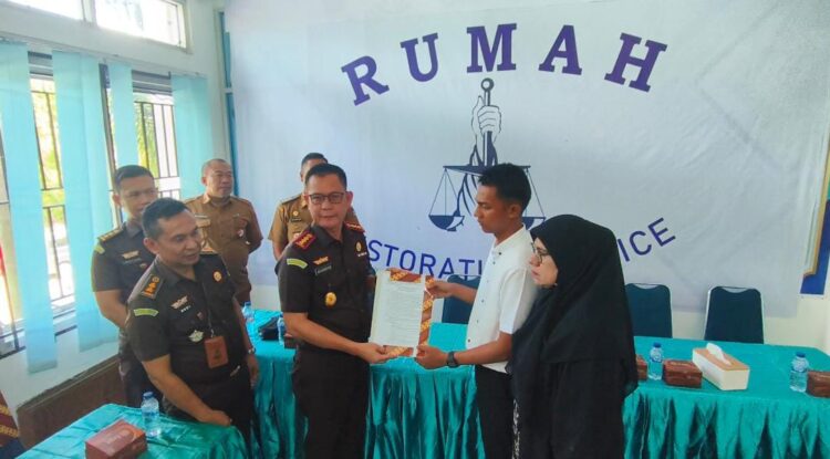 Kajari Padang, Aliansyah menyerakan dokumen pemberhentian tuntutan kepada MI lewat program Restorative justice di Rumah RJ Kecamatan Koto Tangah, Selasa, (26/11).