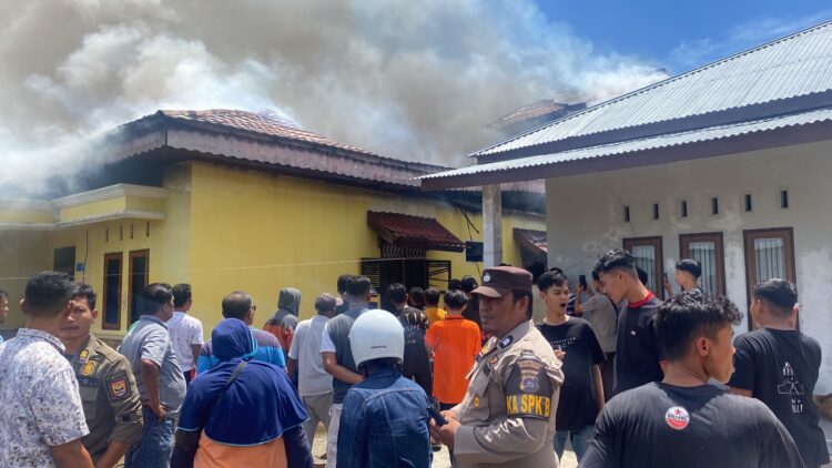 KEBAKARAN— Masyarakat setempat berupaya 
untuk memadamkan api menjelang armada pemadam kebakaran datang.