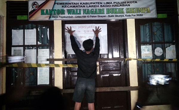 Kecewa Kasus Dugaan Asusila Tak Kunjung Diproses, Kantor Wali Nagari Bukik Sikumpa kembali Disegel Warga 1 DISEGEL— Warga Masyarakat memasang kertas bertulisan saat menyegel Kantor Wali Nagari Bukik Sikumpa, Kecamatan Lareh Sago Halaban, Kabupaten Lima Puluh Kota.